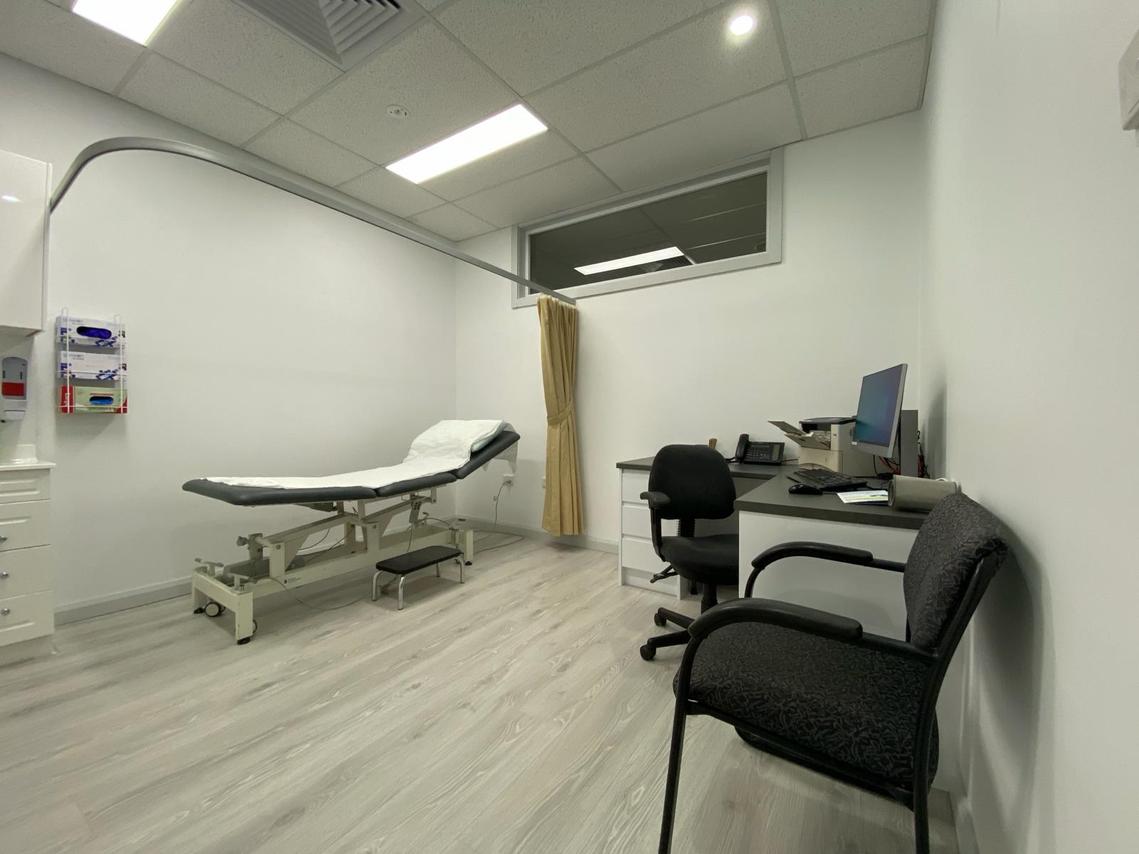 Bright new consultation room with examination bed and desk