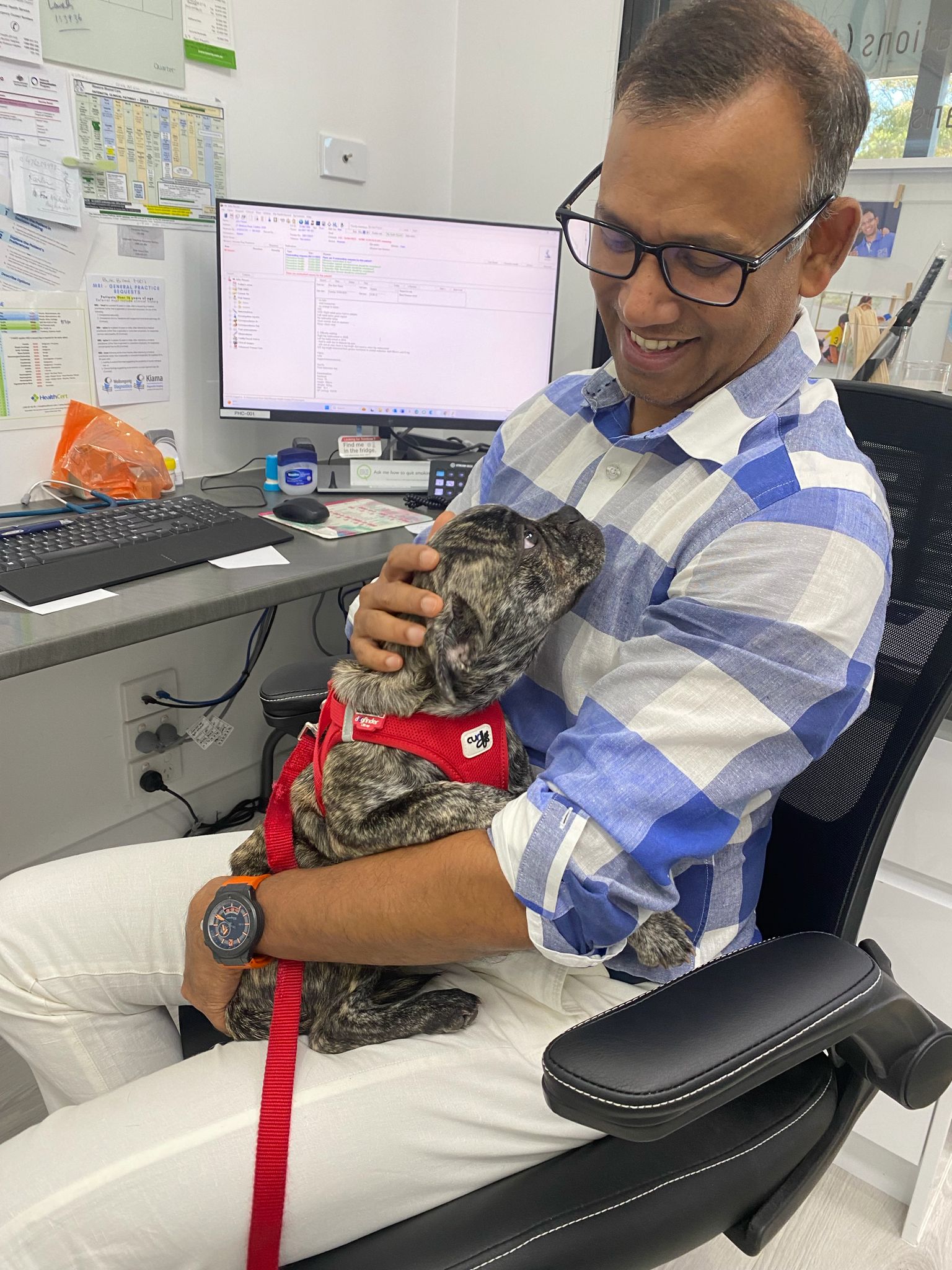 Dr Vakil at his desk with a friendly visiting dog