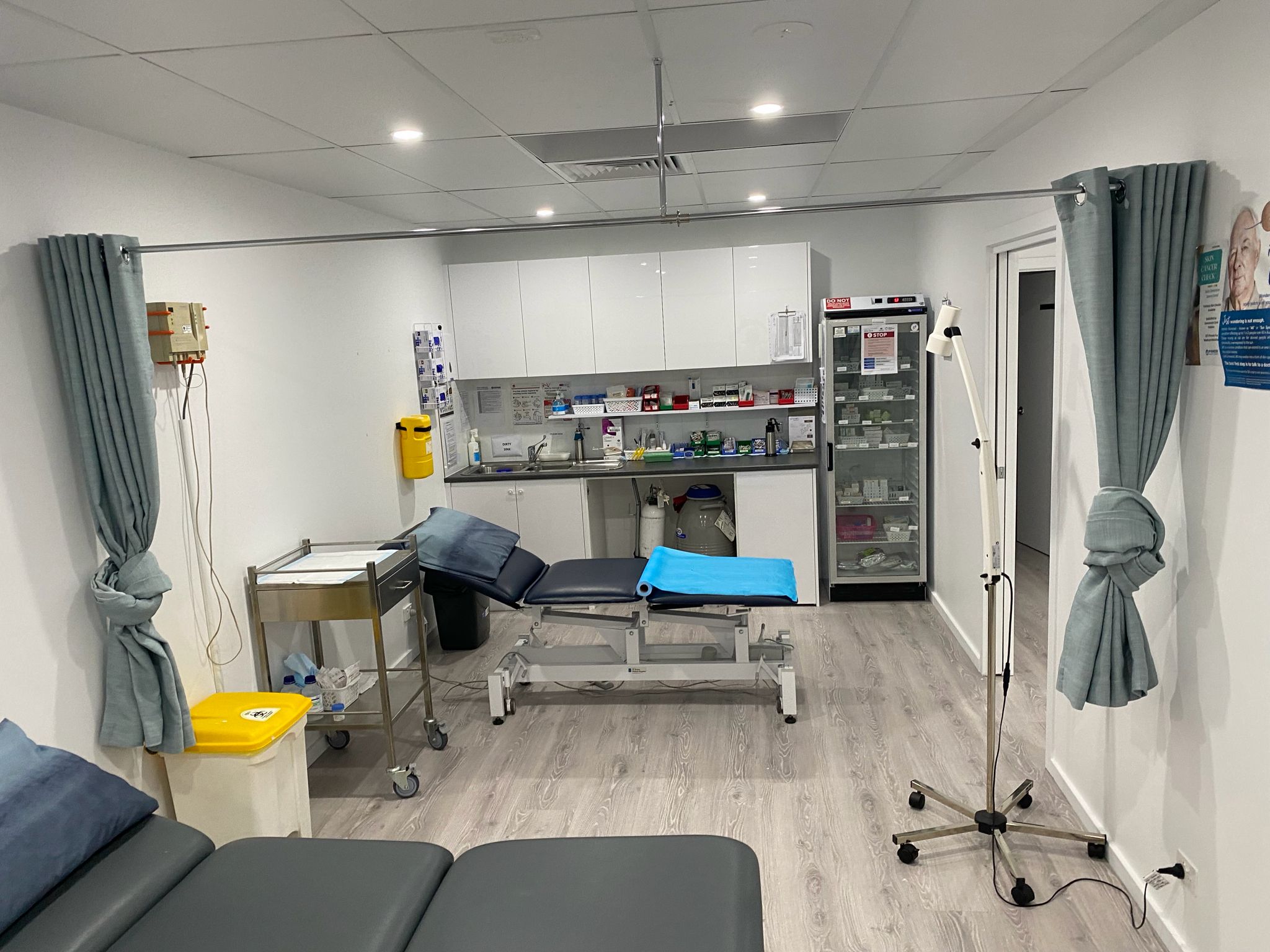 Procedure room with examination tables and vaccine fridge