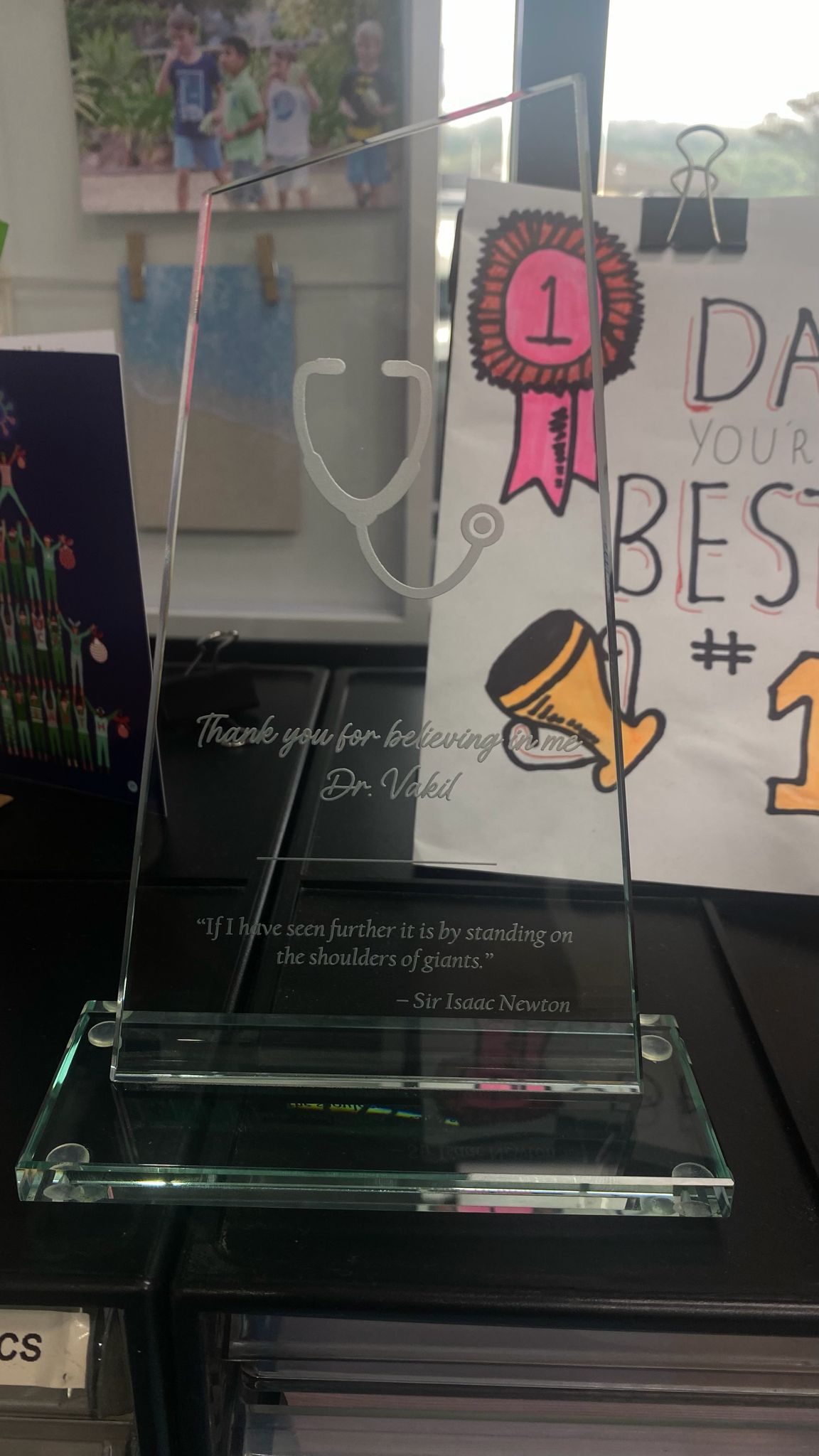 Glass trophy engraved 'Thank you for believing in me, Dr Vakil' with Isaac Newton quote