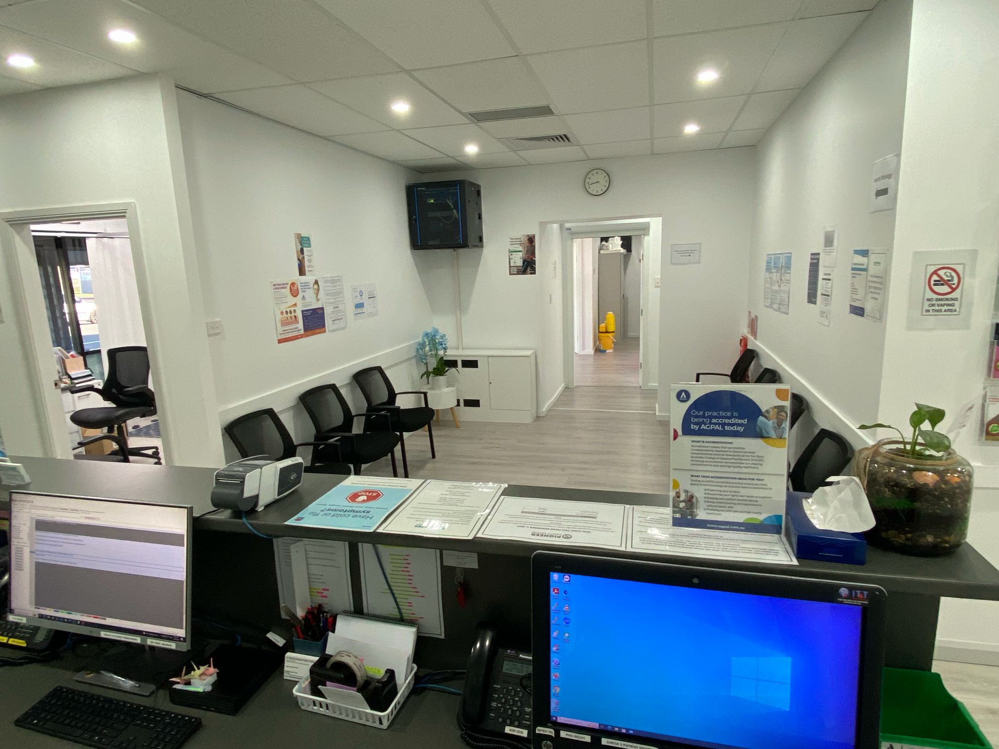 View from reception desk showing waiting area and consulting room hallway